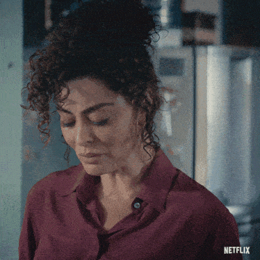 a woman with curly hair and a netflix logo on the bottom