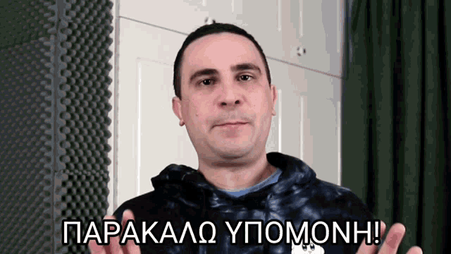 a man in a tie dye hoodie says parakalo ypomonh in greek