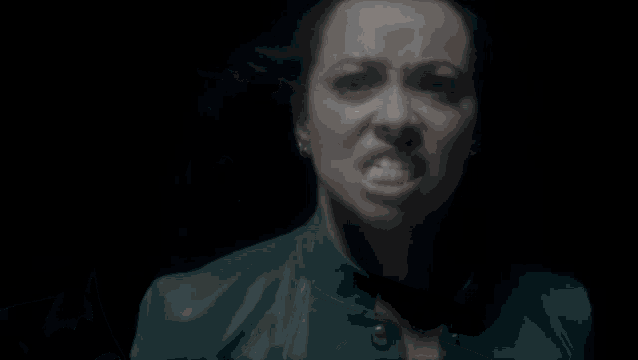 a woman in a green leather jacket is making a silly face
