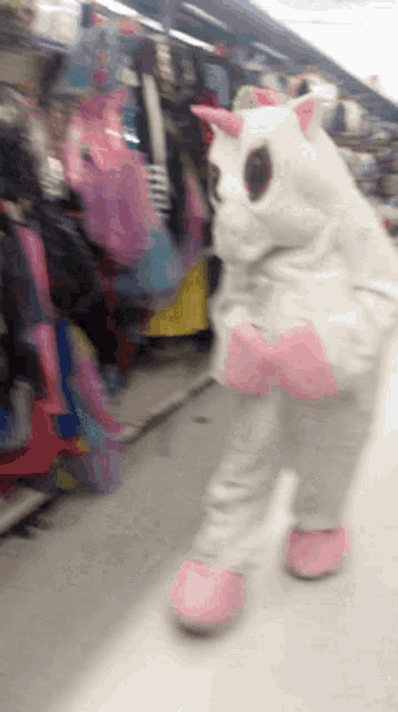 a person dressed in a unicorn costume is walking down a store aisle