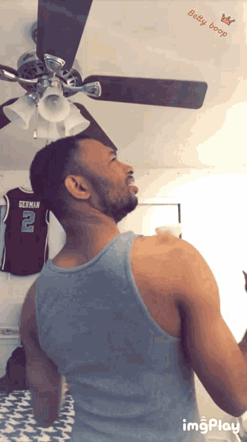 a man in a tank top is standing in front of a german jersey