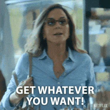 a woman in a blue shirt is holding a purse and saying get whatever you want