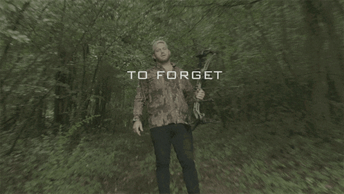 a man in a camo shirt is holding a bow and arrow in the woods and the word who is visible above him