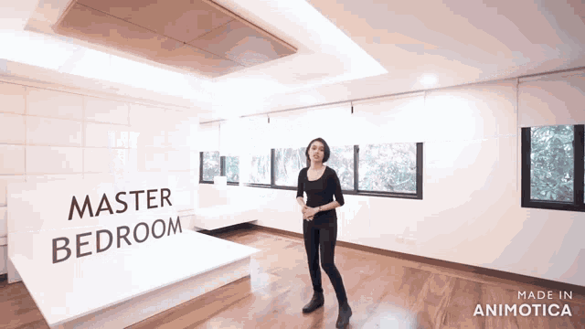 a woman is standing in a room with a sign that says " master bedroom "