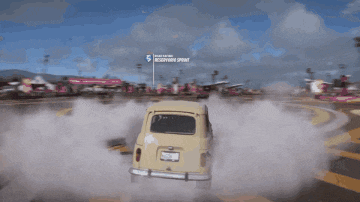 a yellow car is driving down a road with a sign in the background that says " downtown spring "