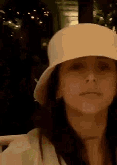 a woman wearing a white hat and a white shirt is making a funny face .