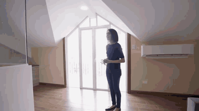 a woman is standing in an empty room with a sliding glass door