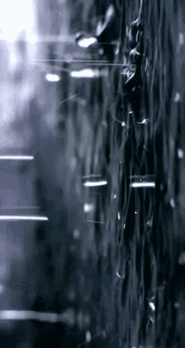 a black and white photo of rain drops on a window