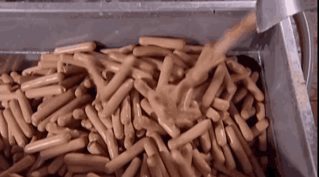 a pile of hot dogs in a metal tray