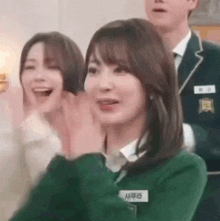 a woman in a school uniform is clapping her hands in a room .
