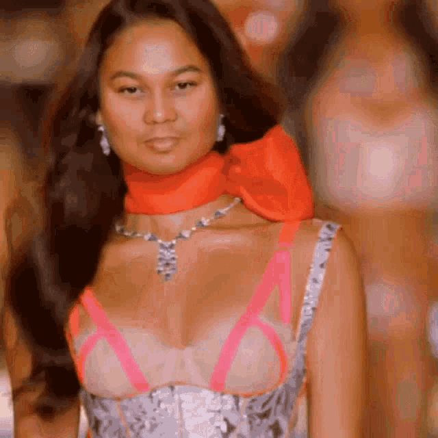 a woman wearing a pink bra and a red scarf