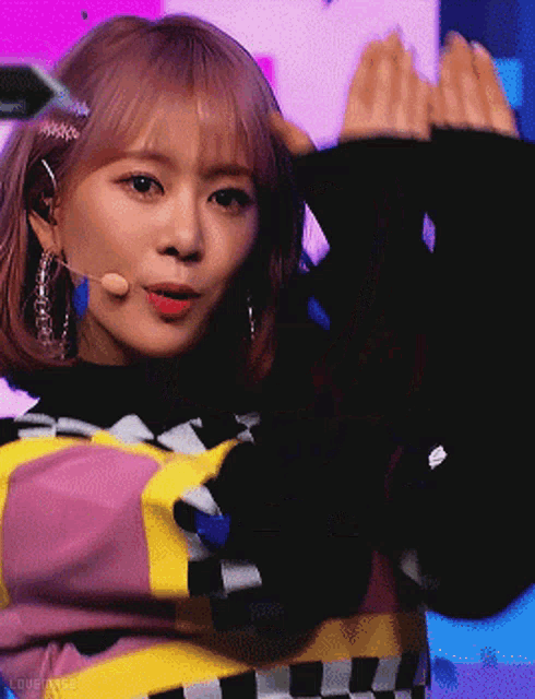 a girl with pink hair is wearing a black sweater