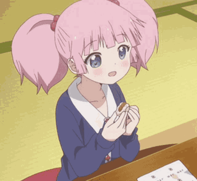 a girl with pink hair is sitting at a table