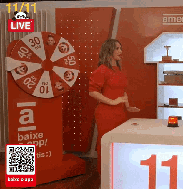 a woman in a red dress is standing in front of a wheel that says live