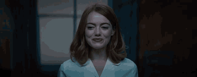 a close up of a woman 's face with a white shirt on
