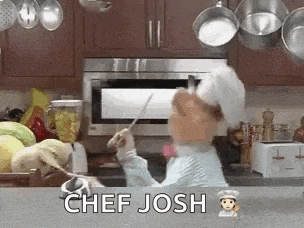 a chef is cooking in a kitchen and holding a spoon in his hand .