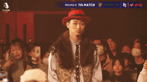 a man in a red hat is standing in front of a crowd and the number 23 is on his chest