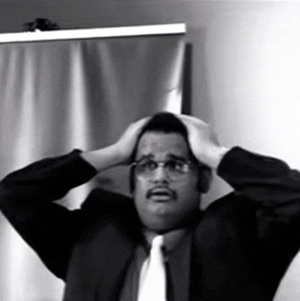 a man in a suit and tie is holding his head in his hands