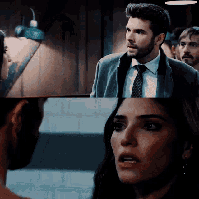a man in a suit and tie looks at a woman
