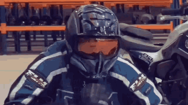 a man wearing a helmet and goggles is sitting in front of a motorcycle .