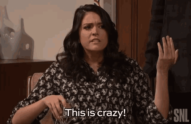 a woman is holding a glass of whiskey and says this is crazy