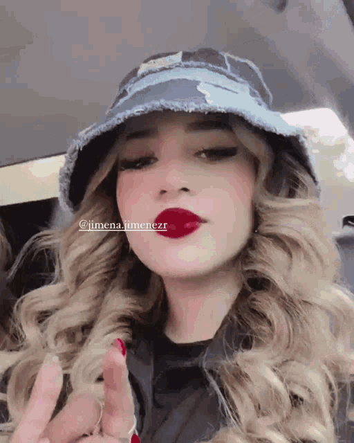 a woman wearing a hat and red lipstick has the name jimena jimenezr on her face