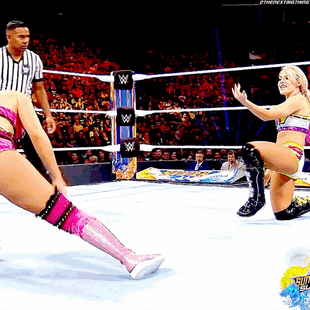 a woman in a wrestling ring with a w logo on the ropes
