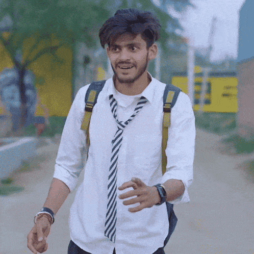 a man wearing a white shirt and tie is walking down a road