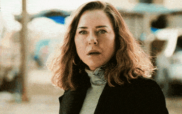 a woman with a surprised look on her face is wearing a black jacket