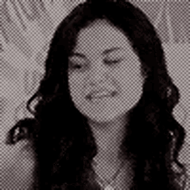 a black and white photo of a woman with long dark hair and a necklace .