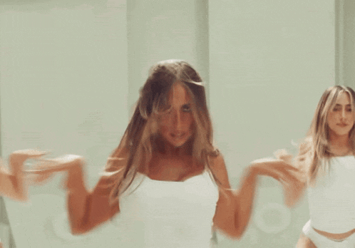a group of women in white lingerie are dancing in a white room