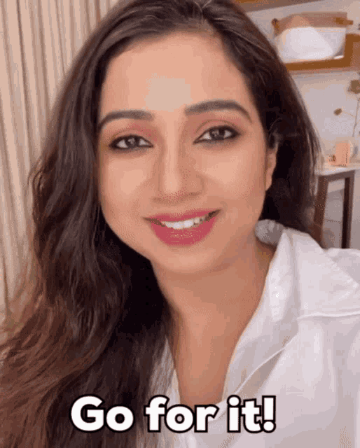a woman in a white shirt is smiling with the words go for it below her