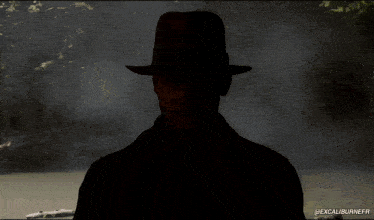 a man wearing a fedora is standing in front of a river with the words @excaliburnefr below him