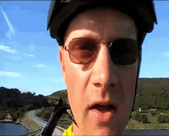 a man wearing sunglasses and a helmet is talking