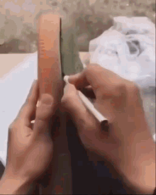 a person is writing on a piece of paper with a pen and a ruler .