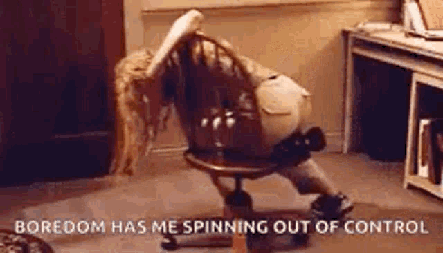 a woman is sitting on a chair with her legs crossed and a caption that says `` boredom has me spinning out of control ''