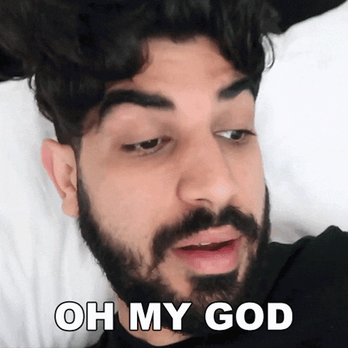 a man with a beard is laying on a bed and says " oh my god "