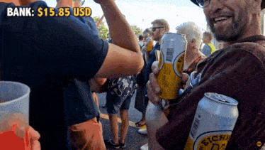 a man holding a can of eichha d2 beer in front of a sign that says bank : $ 15.85 usd