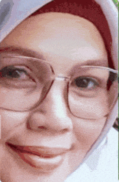 a woman wearing glasses and a hijab is smiling for the camera