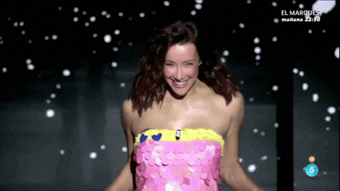a woman in a pink sequined dress is smiling in front of a screen that says el marques mañana 22:50