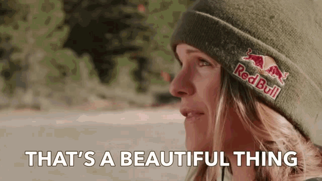 a woman wearing a red bull beanie says " that 's a beautiful thing "