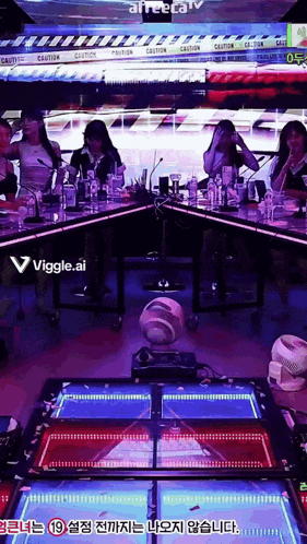 a group of people sitting around a table with a viggle.ai logo in the corner