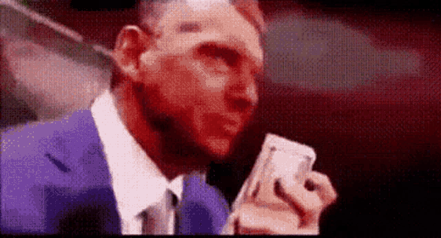 a man in a suit and tie is holding a bunch of money in his hand .