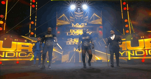 a group of men are standing in front of a sign that says mvp on it