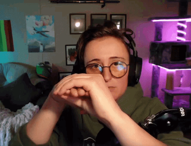 a woman wearing glasses and headphones looks tired