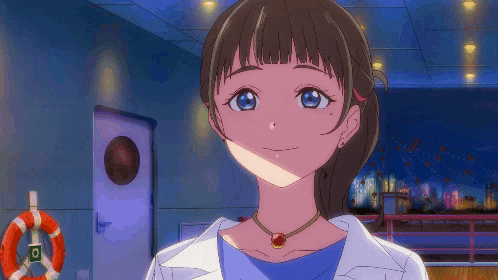 a girl wearing a necklace with a red stone is smiling in front of a life preserver