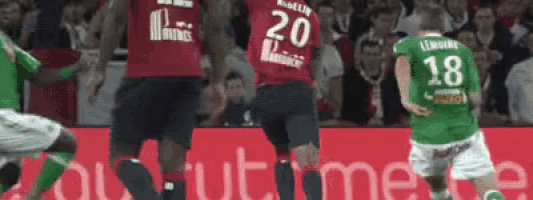 a soccer player wearing a number 20 jersey stands next to another player wearing a number 18 jersey