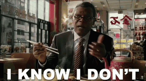 a man in a suit and tie says i know i don 't while holding chopsticks