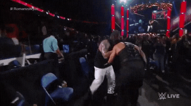 two men are fighting in a wrestling ring .