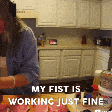 a woman prepares food in a kitchen with the words my fist is working just fine